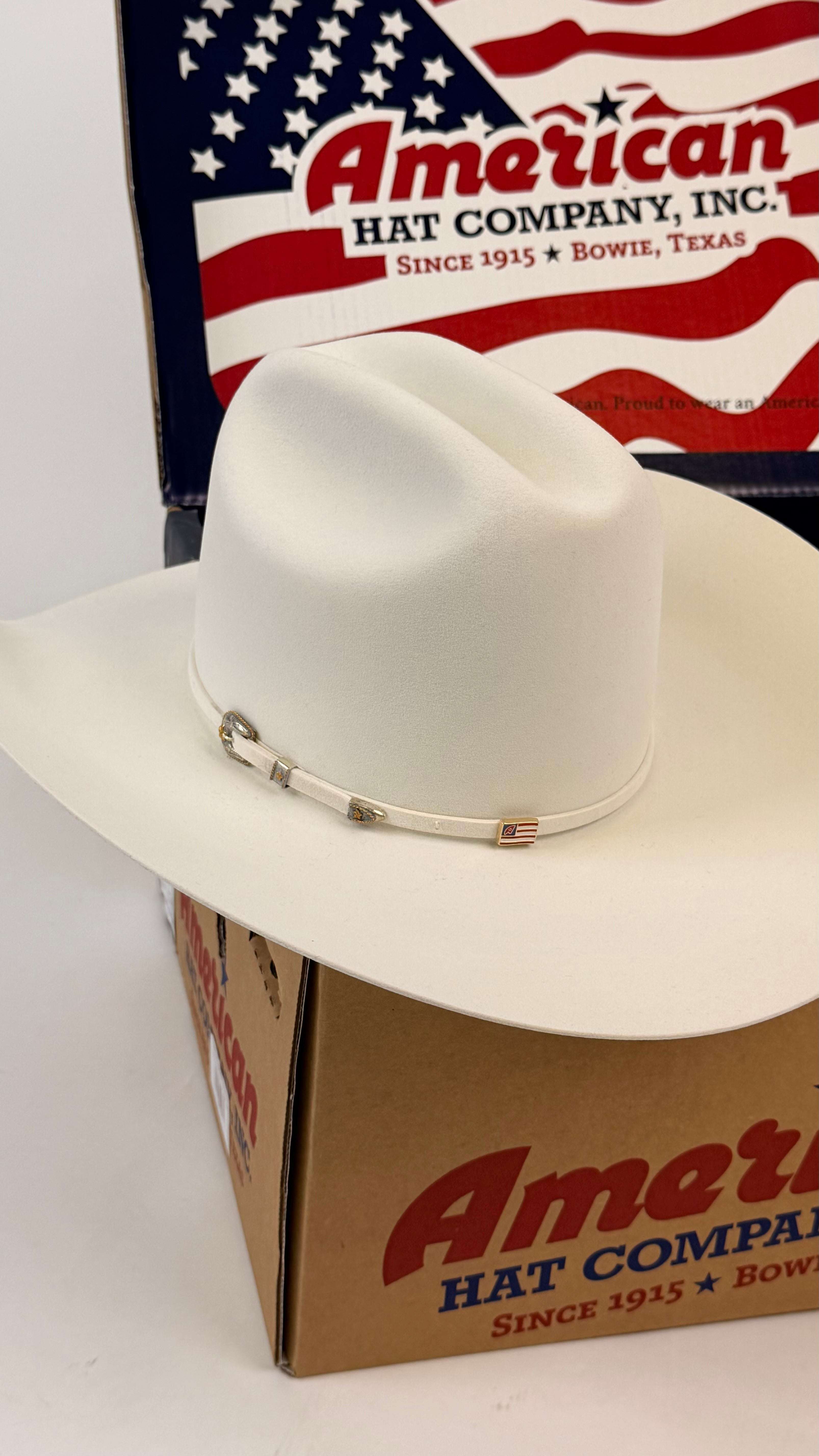 White cowboy hat on an American Hat Company box with a U.S. flag