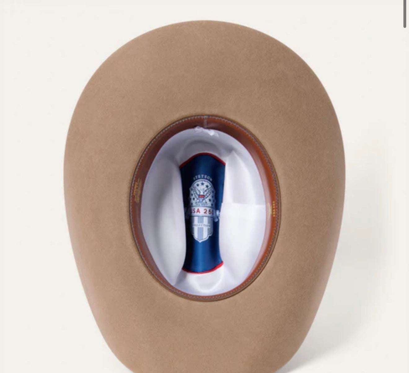 Brown cowboy hat with a blue and red object inside on a white background
