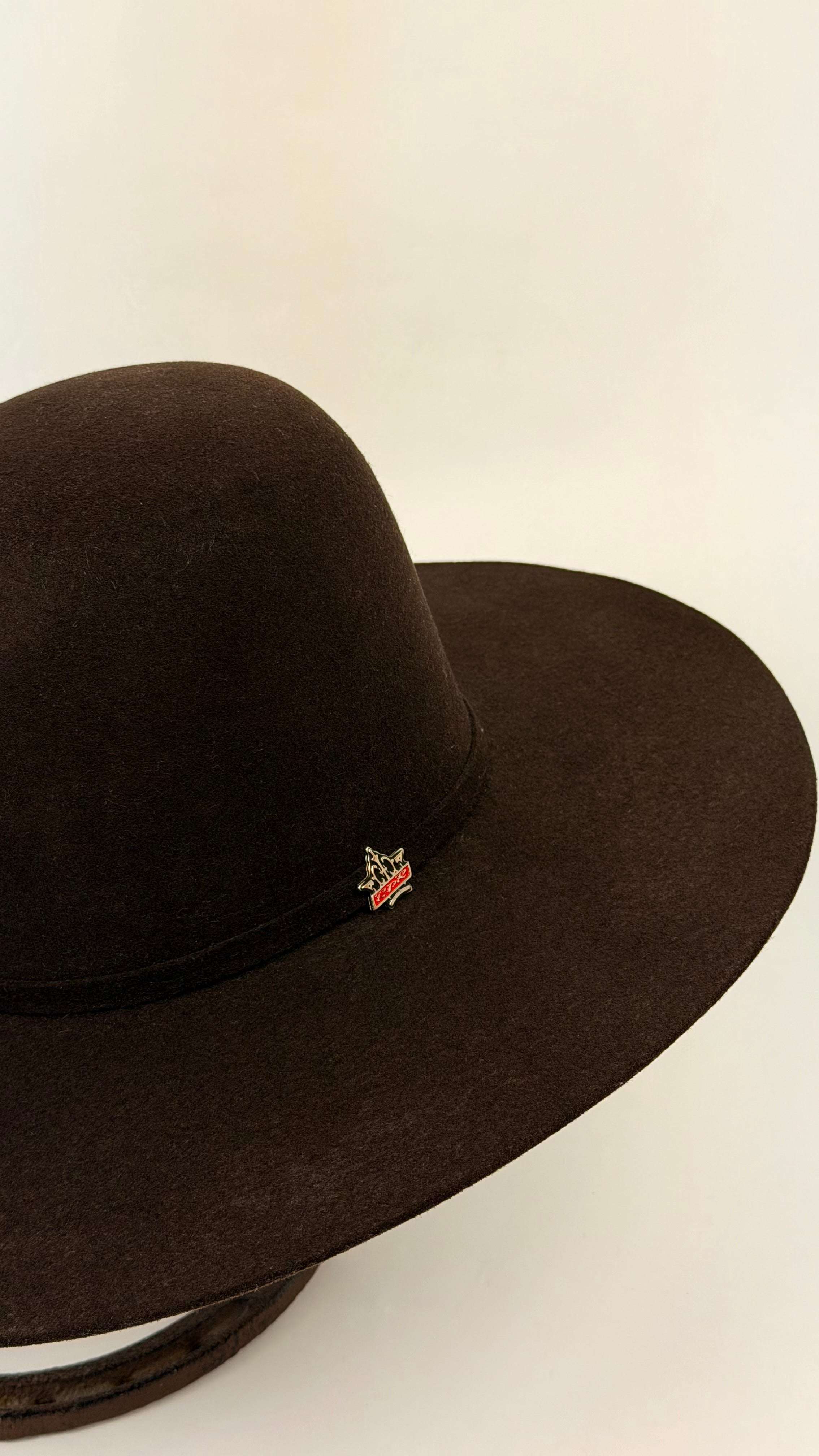 Brown cowboy hat with a brand logo