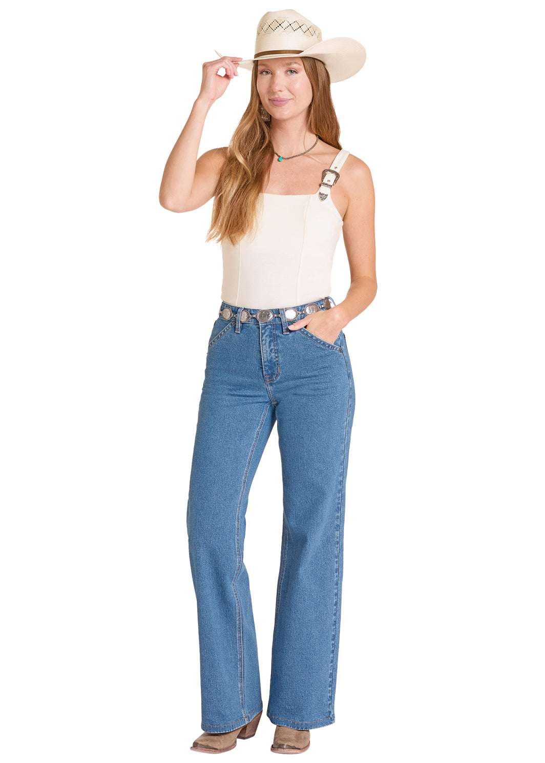 Woman wearing a white tank top, blue jeans, and a beige cowboy hat