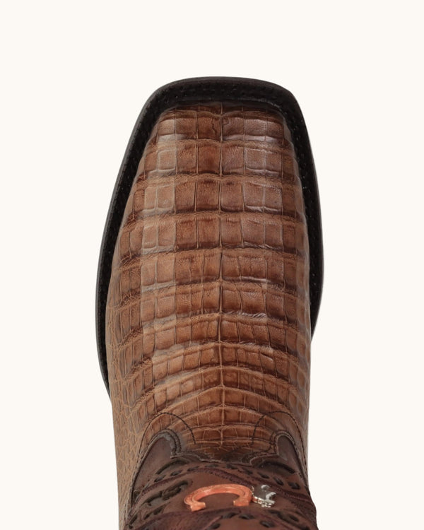 Close-up of a brown crocodile-embossed leather boot on a white background.