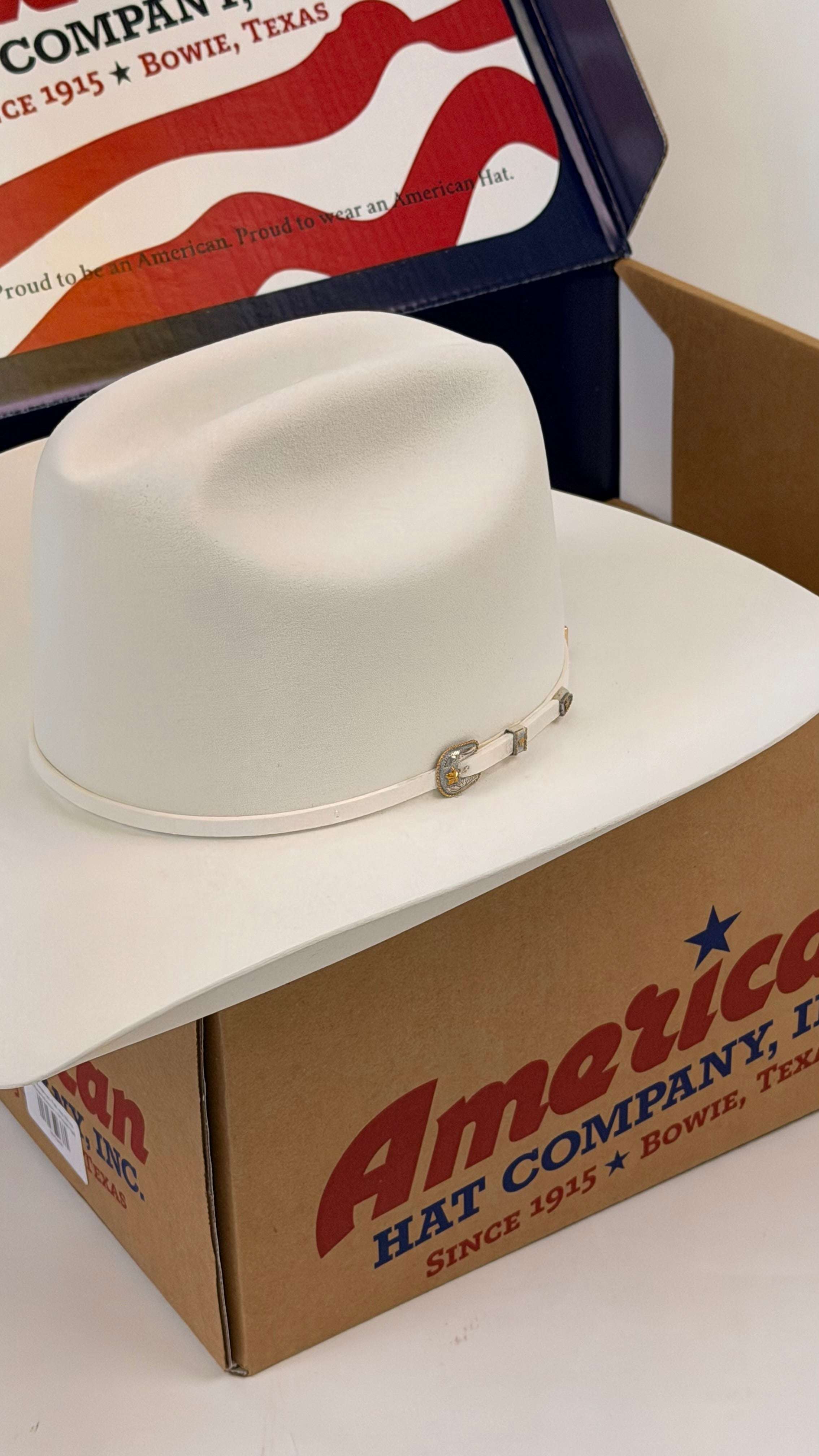 White cowboy hat on a cardboard box with American Hat Company branding.