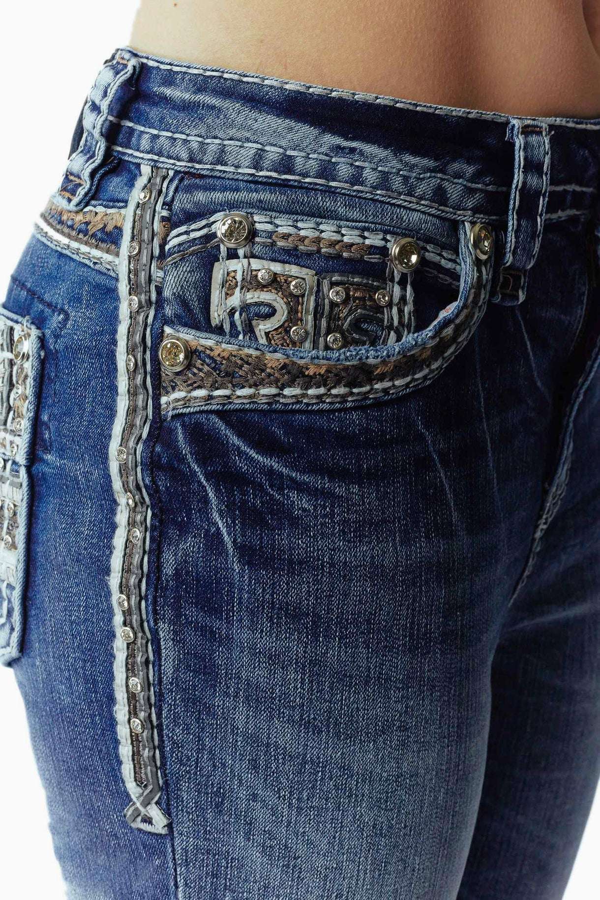 Close-up of blue jeans with decorative stitching and buttons 